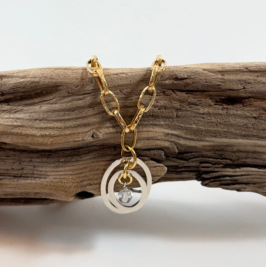 Handgjort halsband med äkta bergkristall och två cirklar i rostfritt. Justerbar kedja i rostfritt stål i 18K guld pvd. Designat av Sussie Brandeby i Helsingborg.