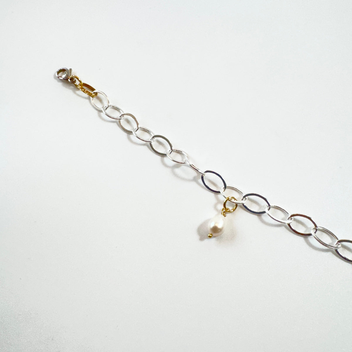 Handgjort armband med äkta vit sötvattenspärla och silverpläterad kedja. Ett nätt och personligt smycke designat av Sussie Brandeby i Helsingborg.