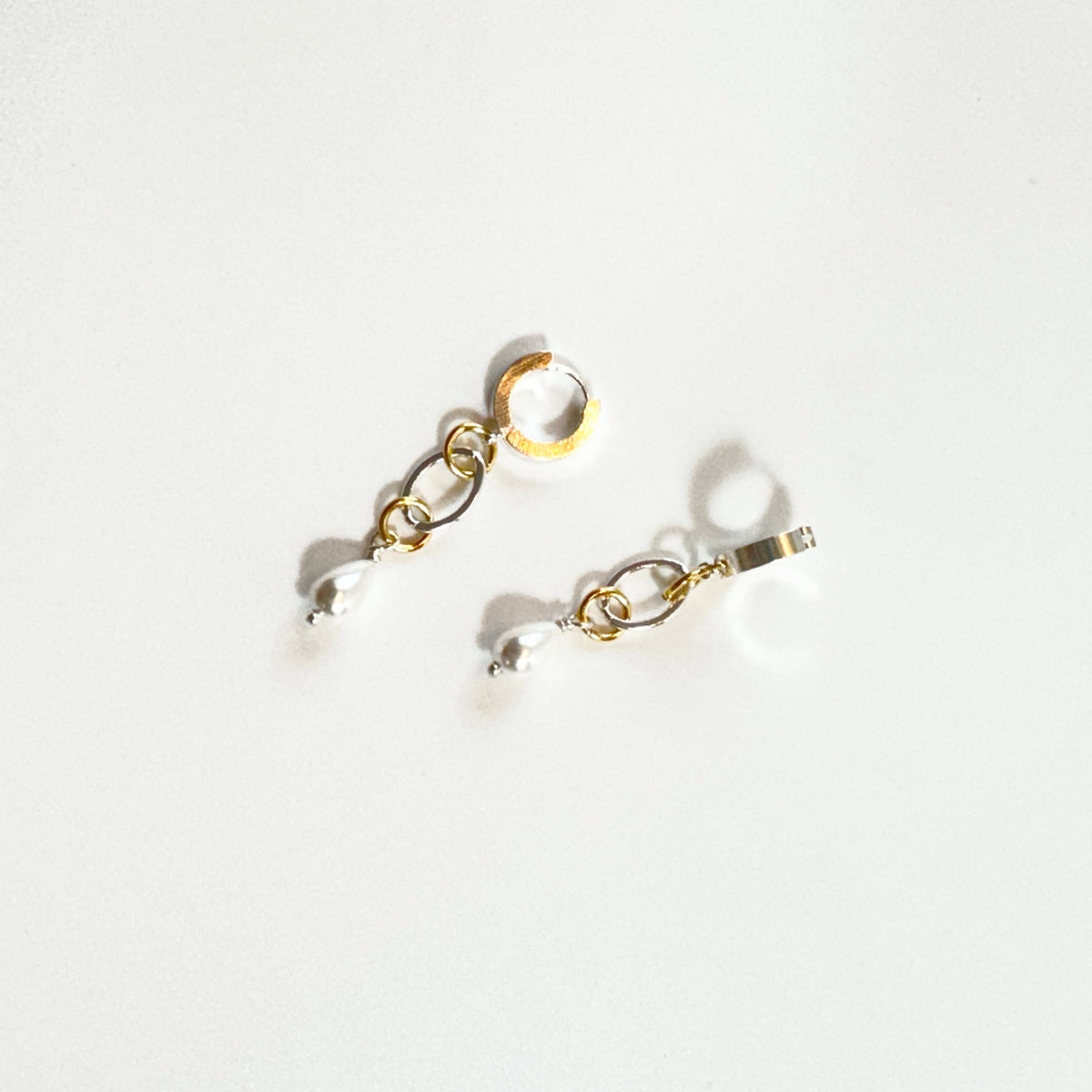 Nätta handgjorda örhängen med snäckskalspärla, silverfärgad creol och detaljer i 18K guld. Enkla att styla och fina att bära. Design av Sussie Brandeby i Helsingborg.