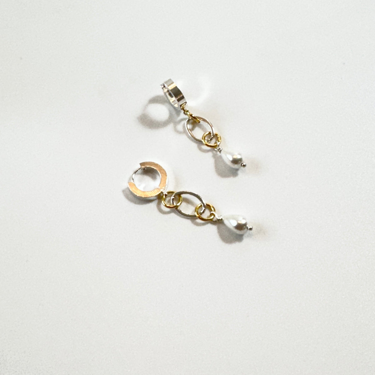 Nätta handgjorda örhängen med snäckskalspärla, silverfärgad creol och detaljer i 18K guld. Enkla att styla och fina att bära. Design av Sussie Brandeby i Helsingborg.