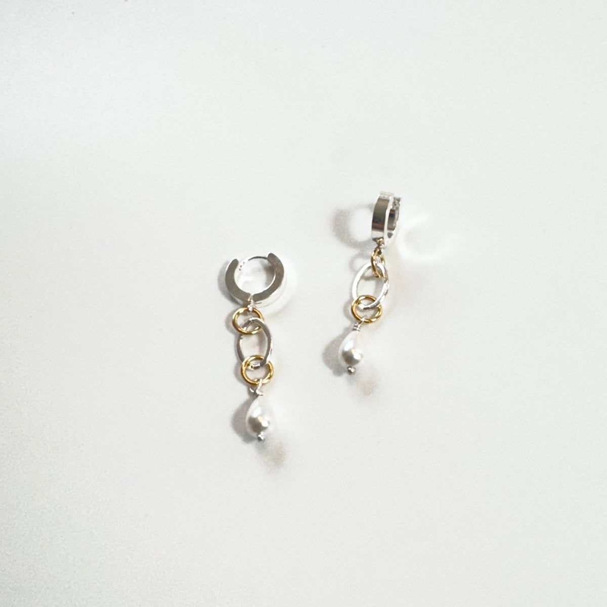Nätta handgjorda örhängen med snäckskalspärla, silverfärgad creol och detaljer i 18K guld. Enkla att styla och fina att bära. Design av Sussie Brandeby i Helsingborg.