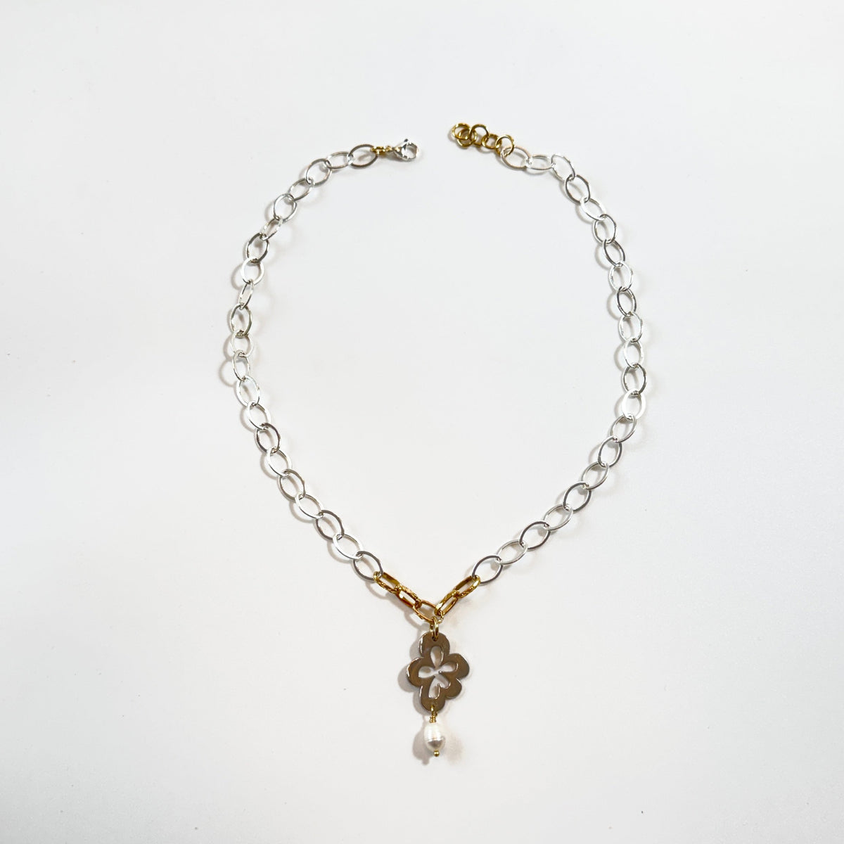Handgjort halsband med silverfärgad kedja, gulddetaljer pvd och egendesignat blomsterhänge i silver. 50 cm långt med karbinhake. Design by Brandeby.