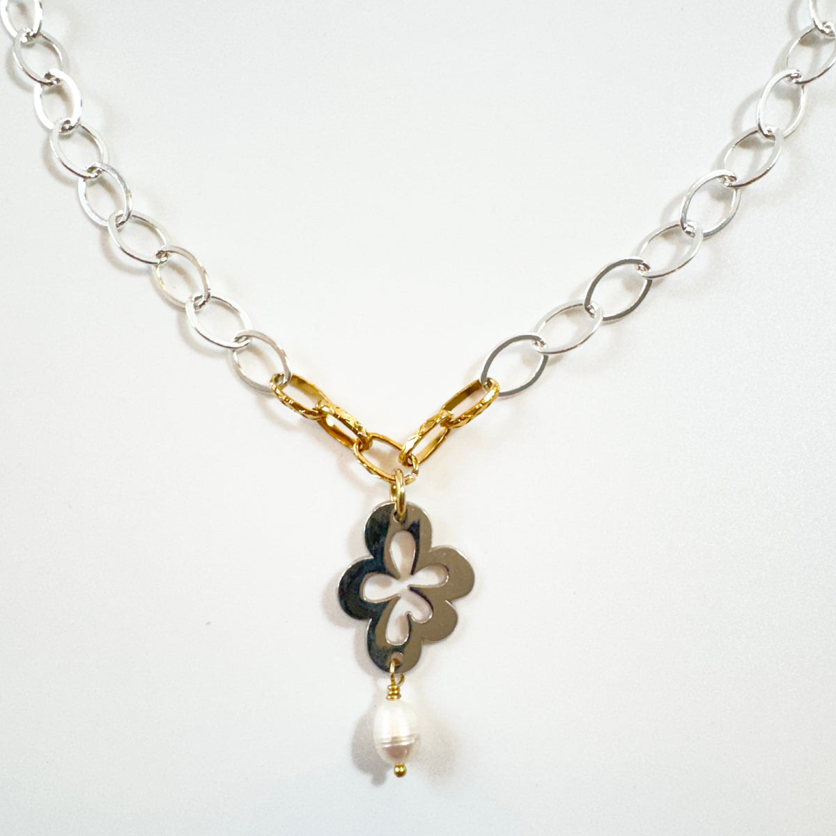Handgjort halsband med silverfärgad kedja, gulddetaljer pvd och egendesignat blomsterhänge i silver. 50 cm långt med karbinhake. Design by Brandeby.