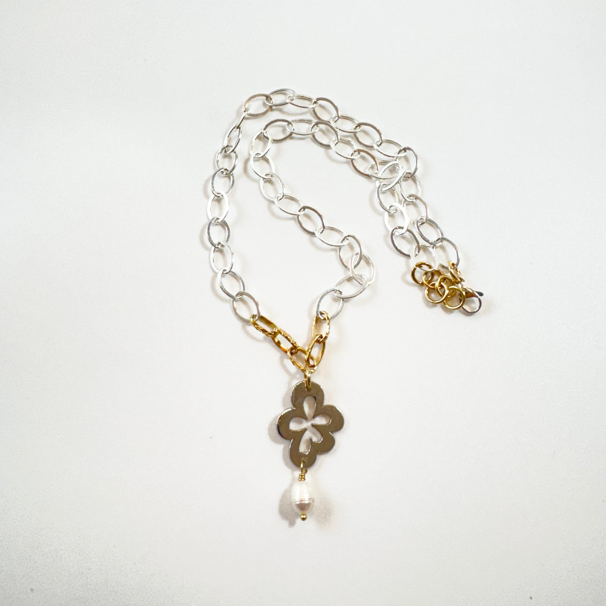 Handgjort halsband med silverfärgad kedja, gulddetaljer pvd och egendesignat blomsterhänge i silver. 50 cm långt med karbinhake. Design by Brandeby.