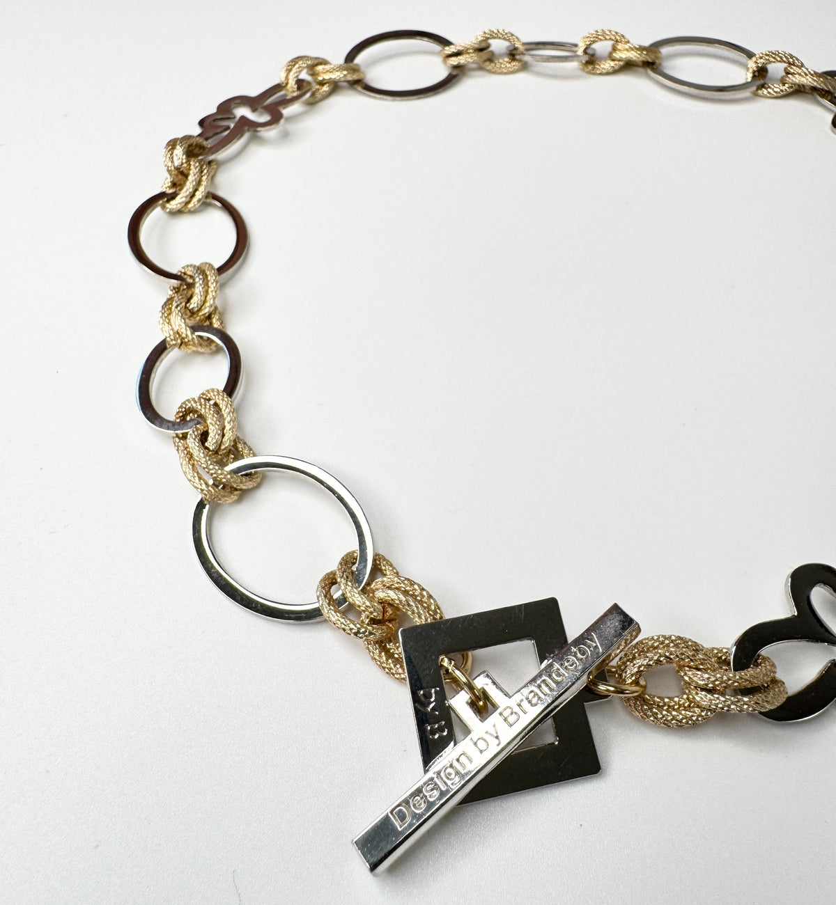 Elegant handgjort halsband med egendesignade blommor och cirklar i silver samt texturerade guldringar i mässing. 50 cm långt. Design by Brandeby