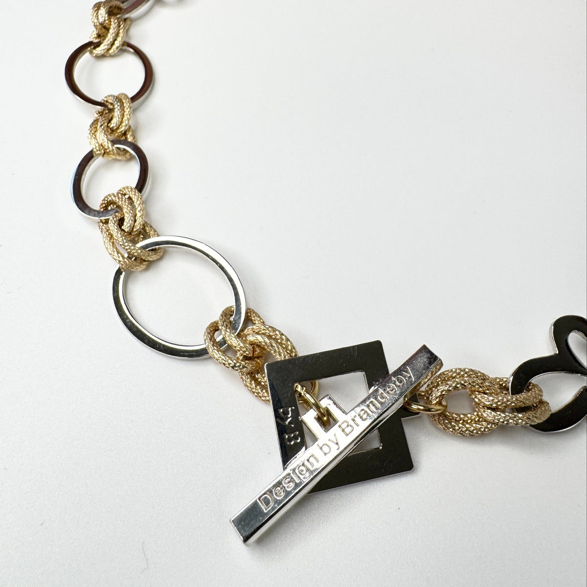 Elegant handgjort halsband med egendesignade blommor och cirklar i silver samt texturerade guldringar i mässing. 50 cm långt. Design by Brandeby