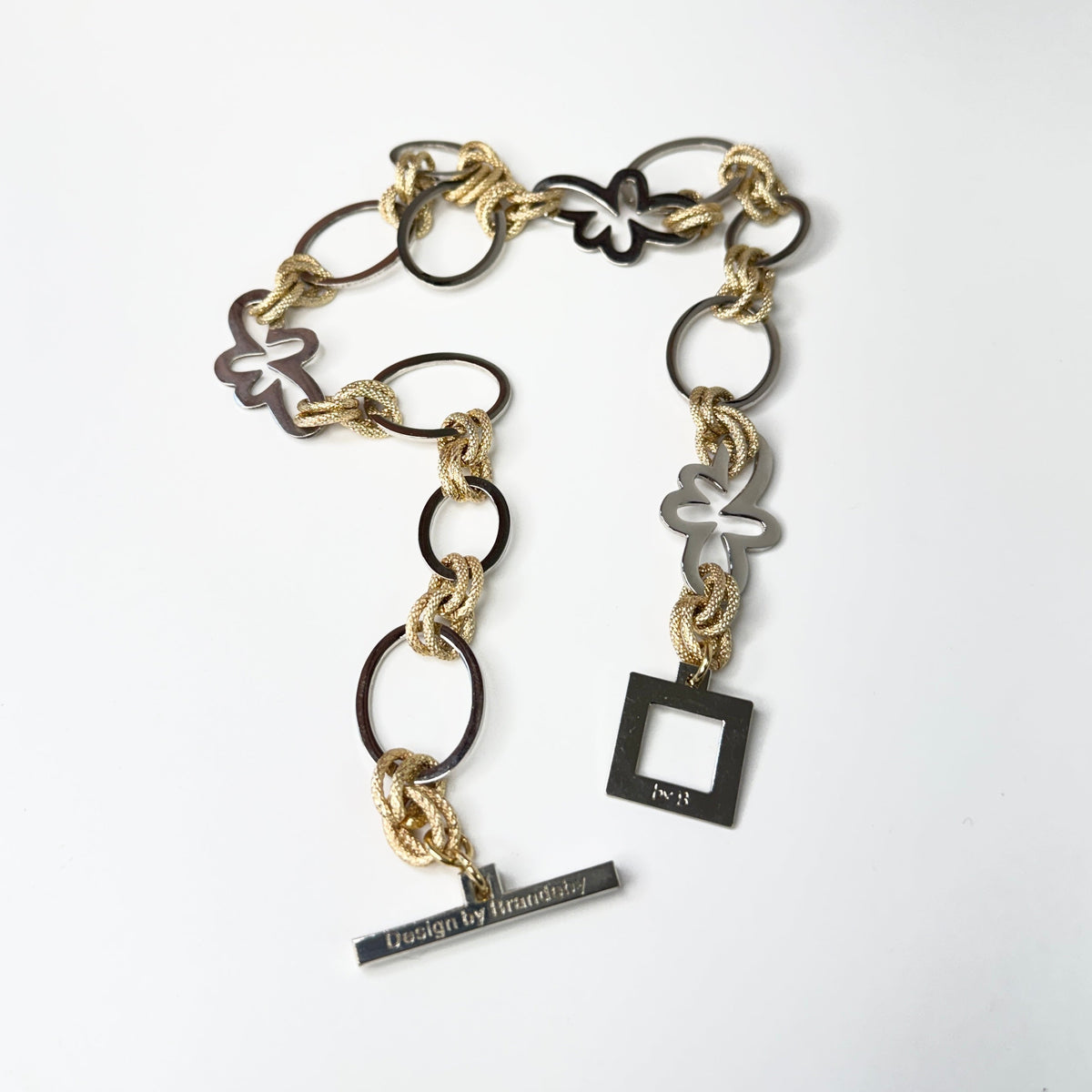 Elegant handgjort halsband med egendesignade blommor och cirklar i silver samt texturerade guldringar i mässing. 50 cm långt. Design by Brandeby
