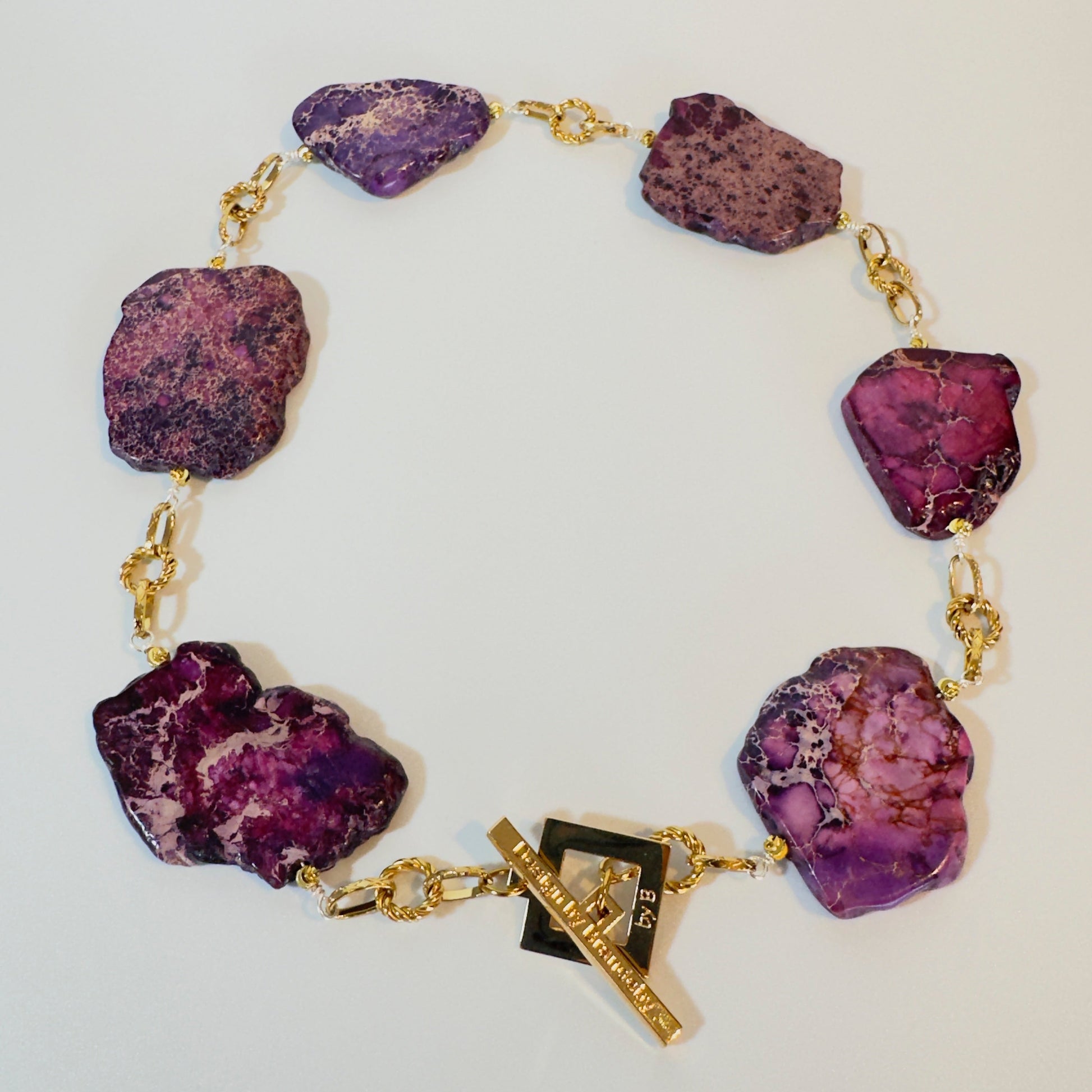Handgjort halsband med äkta lila Imperial Jasper och 18K guld PVD-behandlade detaljer i rostfritt stål. Egendesignat lås, ca 55 cm. Limited Edition från Design by Brandeby.