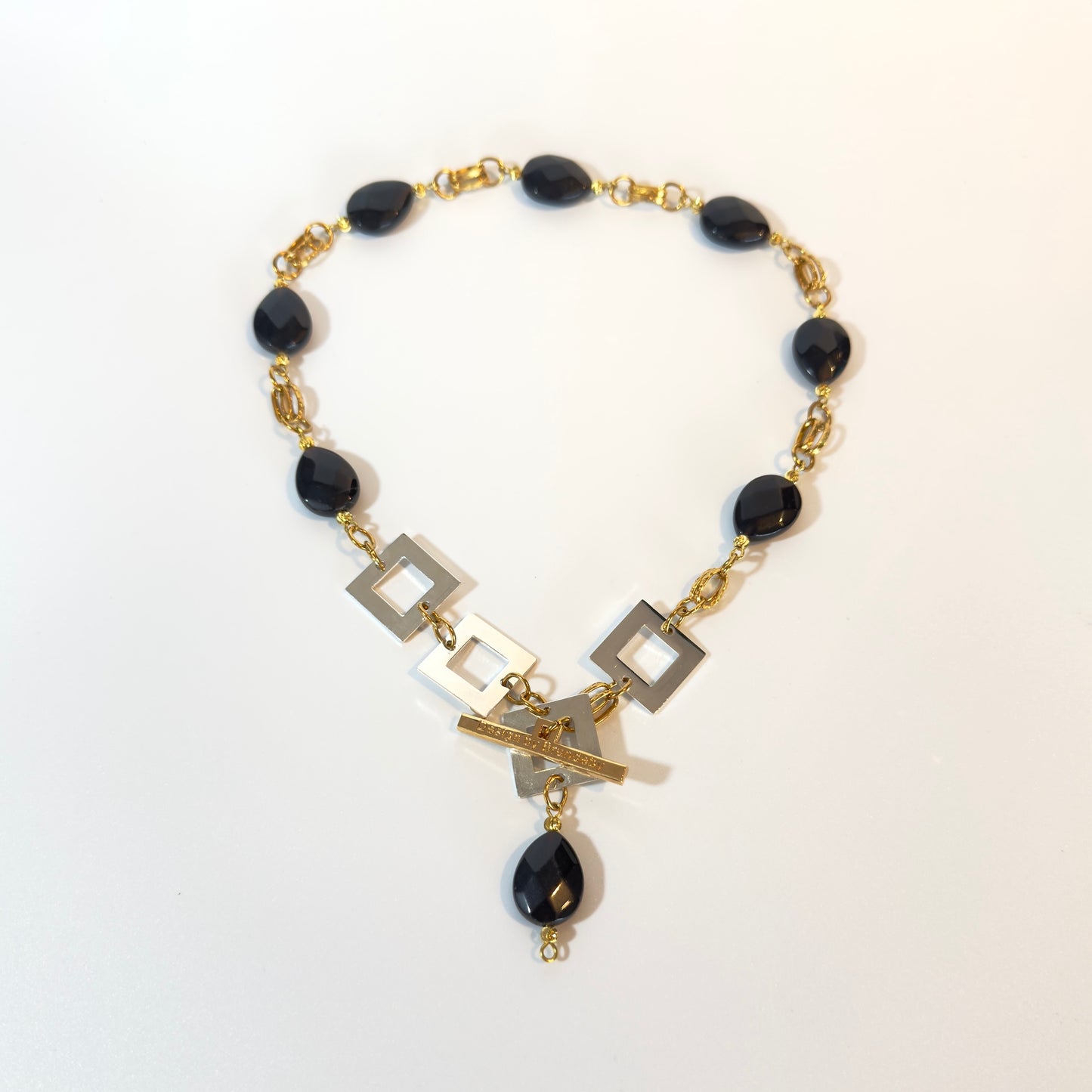 Handgjort halsband med facetterad svart onyx, egendesignat lås och detaljer i 18K guld PVD. Svenskt hantverk i begränsad upplaga från Design by Brandeby.