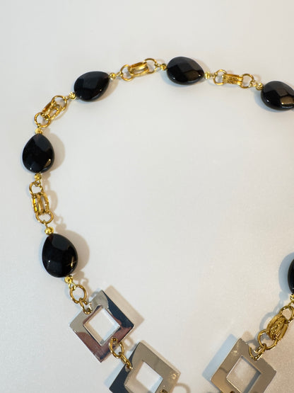 Handgjort halsband med facetterad svart onyx, egendesignat lås och detaljer i 18K guld PVD. Svenskt hantverk i begränsad upplaga från Design by Brandeby.