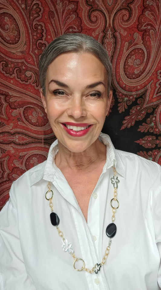eva karin sigetty bär här ett långt halsband från design by brandeby med svarta agat stenar och guld och silver delar 