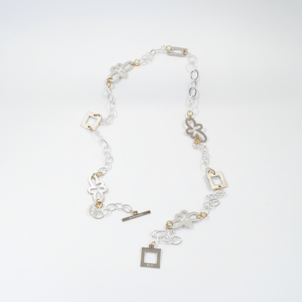 Långt handgjort halsband med egendesignade fyrkanter och blommor, silverpläterad mässingskedja och detaljer i 18K guld PVD. Bär på flera sätt. Design by Brandeby