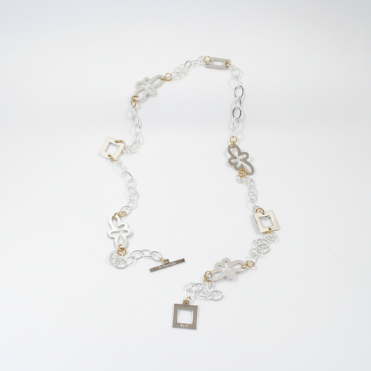 Långt handgjort halsband med egendesignade fyrkanter och blommor, silverpläterad mässingskedja och detaljer i 18K guld PVD. Bär på flera sätt. Design by Brandeby