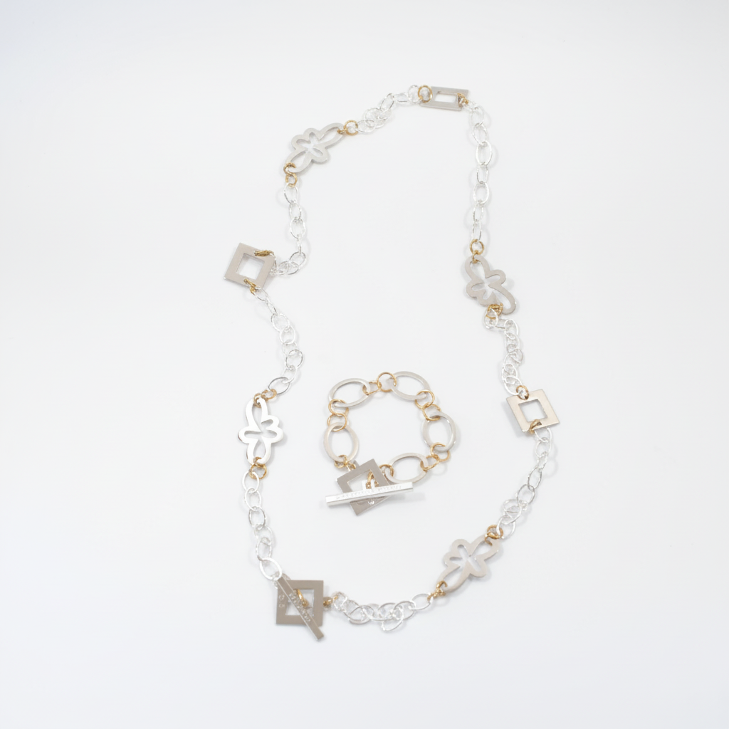 Långt handgjort halsband med egendesignade fyrkanter och blommor, silverpläterad mässingskedja och detaljer i 18K guld PVD. Bär på flera sätt. Design by Brandeby