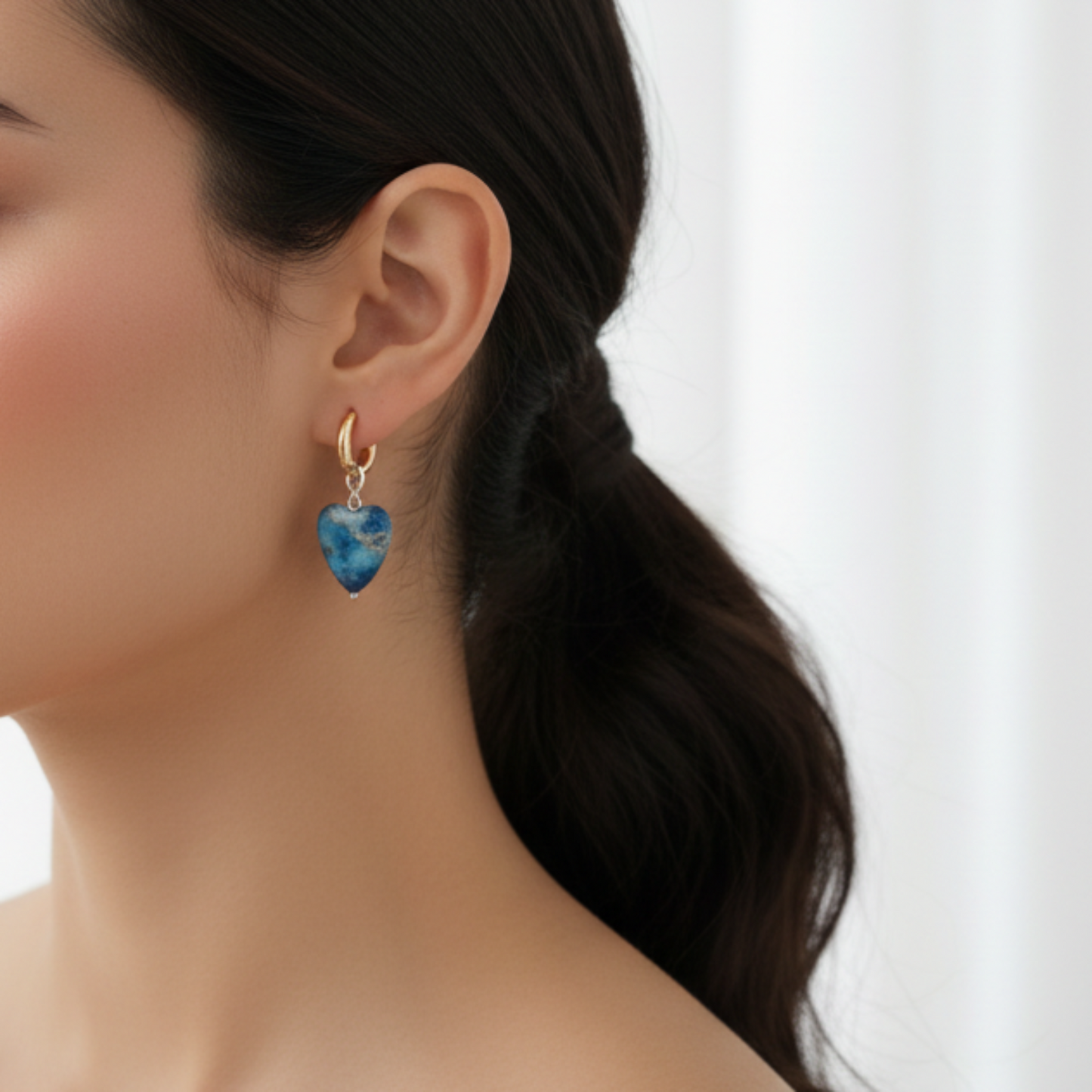 Kvinna i profil med mindre blå ädelstensörhängen