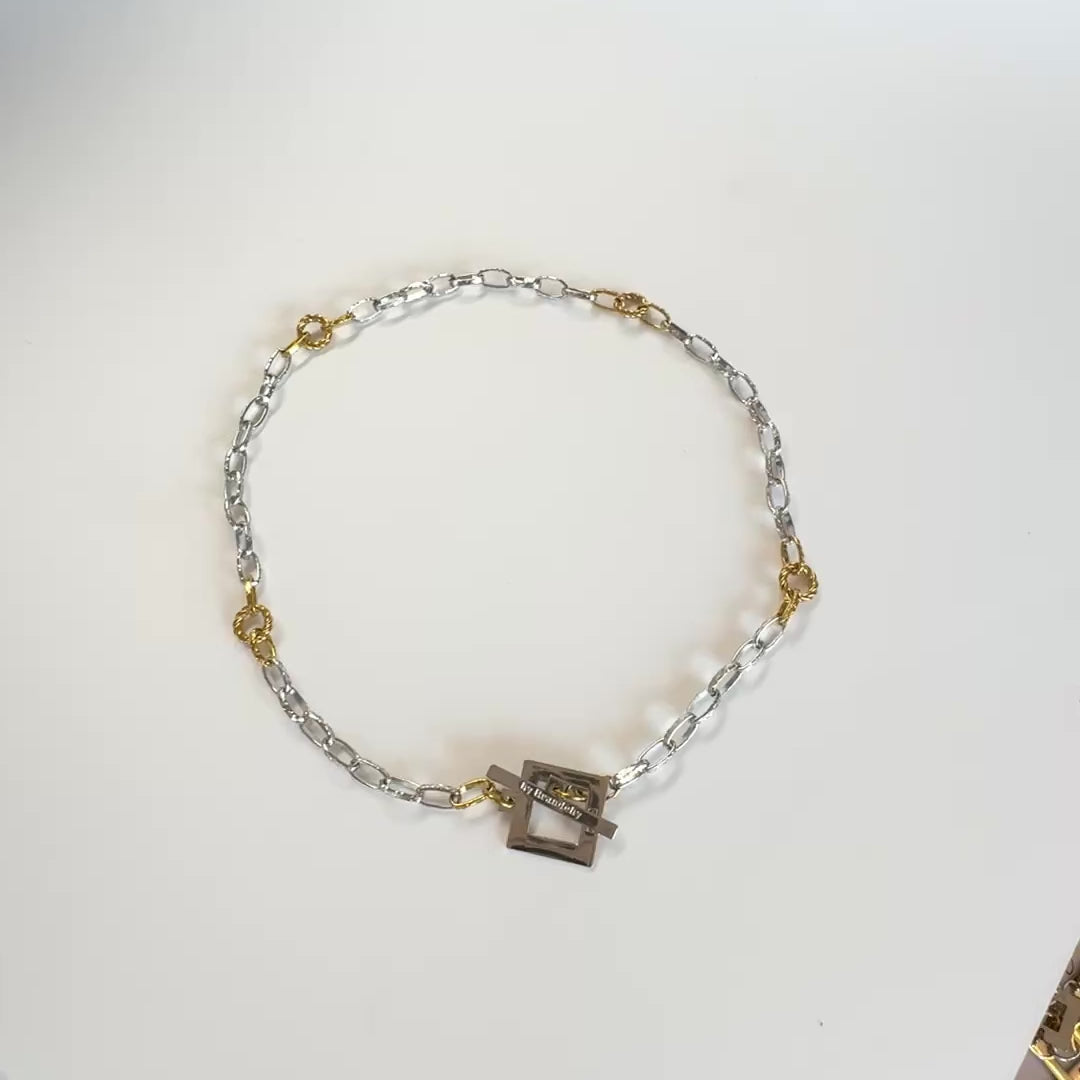 Elegant kedjehalsband i silver och guld med handgjord texturerad kedja, egendesignat lås och 18K guld PVD-belagda detaljer. Ett modernt och tidlöst halsband för både vardag och fest. Design by Brandeby.