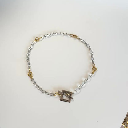 Elegant kedjehalsband i silver och guld med handgjord texturerad kedja, egendesignat lås och 18K guld PVD-belagda detaljer. Ett modernt och tidlöst halsband för både vardag och fest. Design by Brandeby.