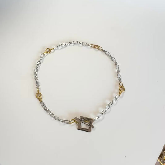 Elegant kedjehalsband i silver och guld med handgjord texturerad kedja, egendesignat lås och 18K guld PVD-belagda detaljer. Ett modernt och tidlöst halsband för både vardag och fest. Design by Brandeby.