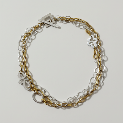 Handgjort halsband med tre rader egendesignade blommor i sterling silver och 18K guld PVD. Svensk design i begränsad upplaga från Design by Brandeby.